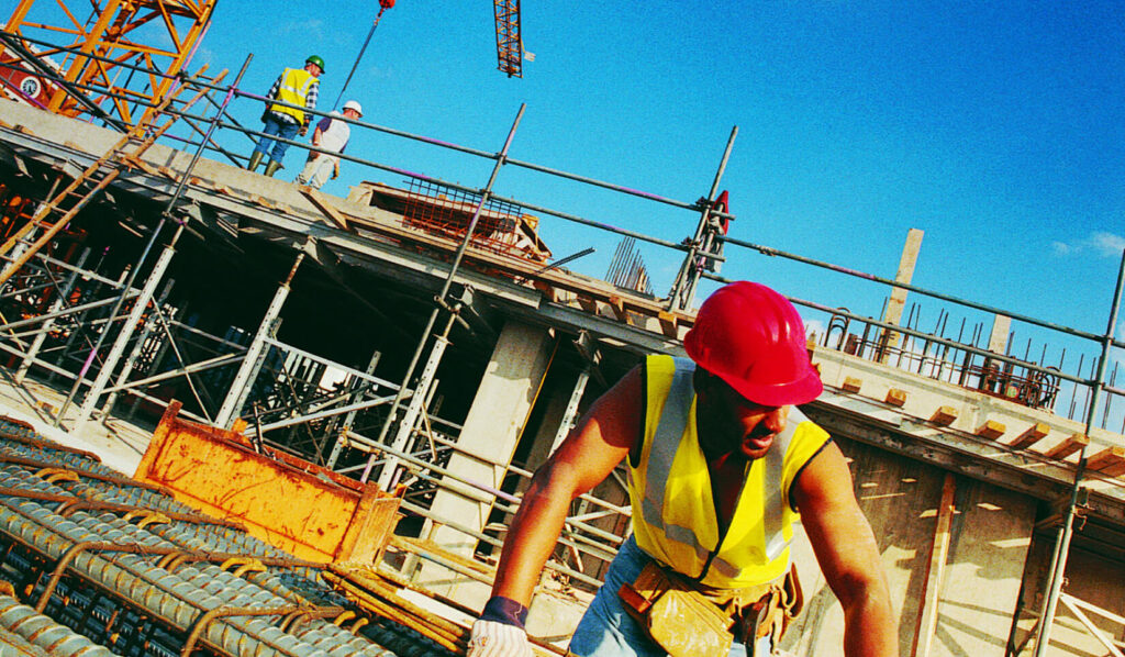 Rectangular photo of men working on construction of a bridge