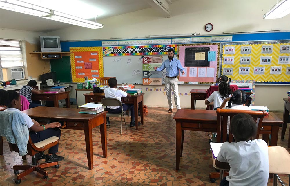 John Hamilton teaching in front of a class of young kids