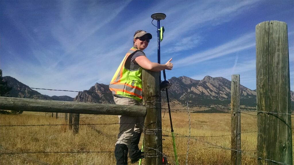 Kayce D.W. Keane working in the field with a thumbs up.